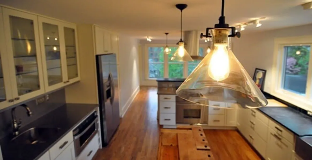 Residential electrician installing modern indoor light fixture in a home in Naperville, IL
